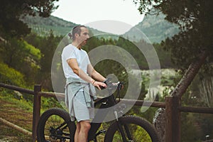 Portrait of a Caucasian young athletic man using electric bike, bicycle, riding in mountains