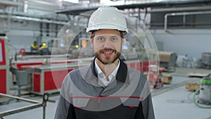 Portrait of caucasian young bearded professional male engineer man in hard hat