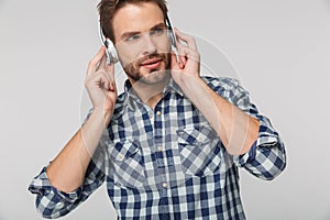 Portrait of caucasian young man wearing plaid shirt using headphones