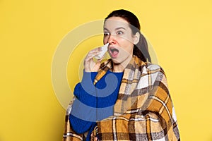 Portrait of Caucasian young woman flu and cold, feeling sick posing isolated on yellow studio background.