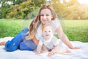 Portrait of Caucasians baby (boy) and his mother. Child (kid) and mom (woman) enjoying summer day