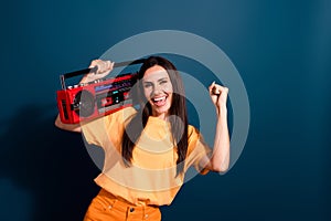 Portrait of champion in dj battle young woman fist up likes loud music holding tape recorder isolated on dark blue color
