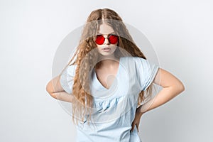 Portrait of charismatic modern girl in round red spectacles posing isolated on white wall background