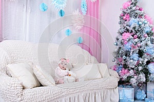 Portrait of charming baby girl dressed in pink clothes sitting o