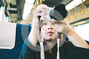 Portrait charming beautiful traveler woman. Attractive beautiful woman in the train and taking a photo of frineds.
