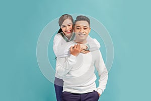 Portrait of charming couple hugging looking isolated over light blue background