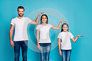 Portrait of charming family holding palm wearing white t-shirt denim jeans isolated over blue background