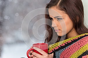 Portrait of charming girl in sweater holding cup.