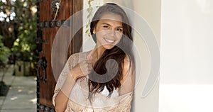 Smiling woman leaning against wall on resort photo