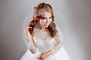 Portrait of a charming red-haired bride, Studio, close-up. Wedding hairstyle and makeup.