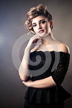 Portrait charming woman in black dress with retro hairstyle