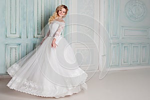 Portrait of charming woman in wedding dress. Dancing on the background walls with classic moldings