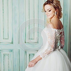 Portrait of charming woman in wedding dress. Dancing on the background walls with classic moldings