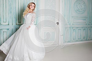 Portrait of charming woman in wedding dress. Dancing on the background walls with classic moldings