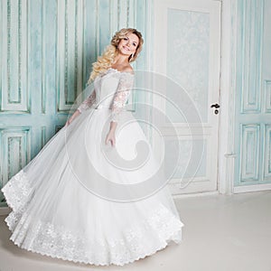 Portrait of charming woman in wedding dress. Dancing on the background walls with classic moldings