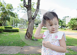 3 years old Asian little girl scratching her head