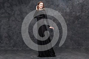 Portrait of charming young woman in long black dress