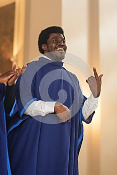 Portrait of Cheerful African American Man in Blue Robe in Sunday Church. Black Christian Male Gospel