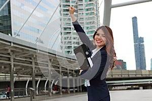 Portrait of cheerful Asian businesswoman looking confident and smiling in the city background. Successfull business concept.
