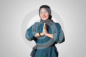 Portrait of cheerful Asian woman hijab in casual shirt, showing apologize and welcome hand gesture. Advertising concept. Isolated