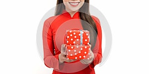 Portrait of cheerful Asian young lady in vietnamese tranditional costume with giftboxes preparing for Lunar New Year celebration