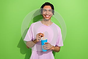 Portrait of cheerful attractive person toothy smile hands hold soda drink straw cup isolated on green color background