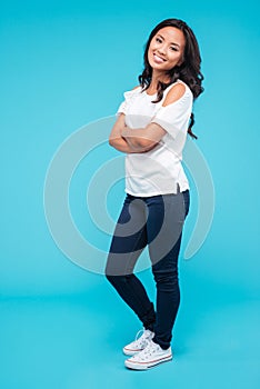 Portrait of a cheerful beautiful asian woman with arms folded