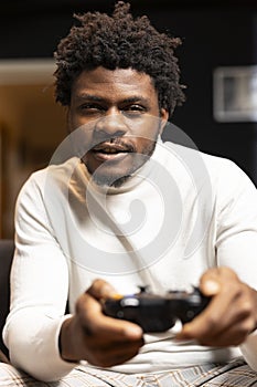 Portrait of cheerful BIPOC gamer engaging in online competitive multiplayer game