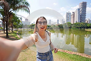 Portrait of cheerful Brazilian girl takes selfie in Vaca Brava Park in Goiania, Goias, Brazil