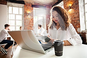 Portrait of cheerful business African-American lady working on laptop.