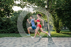 Portrait of cheerful caucasian couple running outdoors