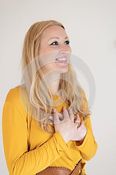 Portrait of cheerful confident beautiful woman with long blond hair, wearing casual clothes, standing in relaxed pose