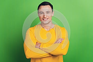 Portrait of cheerful cool guy folded arms toothy beaming smile on green background