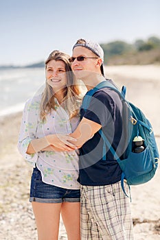 Portrait of a cheerful couple hugging on beach of Baltic Sea