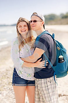 Portrait of a cheerful couple hugging on beach of Baltic Sea