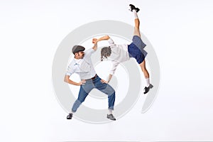 Portrait of cheerful couple, man and woman, dancing boogie woogie isolated over white studio background