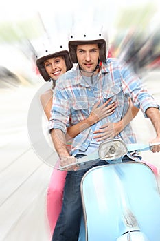 Portrait of cheerful couple riding the moto