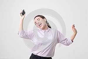 Portrait of a cheerful cute woman listening music and dancing isolated