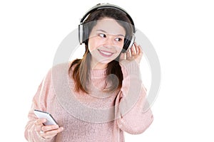 Portrait of cheerful cute young woman listening music in headphones isolated on white background Using phone