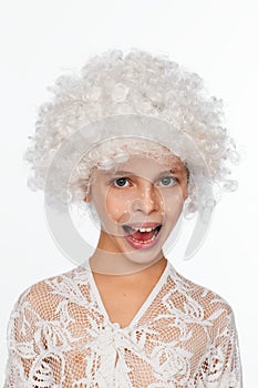 Portrait of a cheerful, energetic eight-year-old girl in a white wig and with white freckles