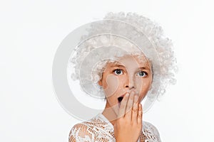 Portrait of a cheerful, energetic eight-year-old girl in a white wig and with white freckles