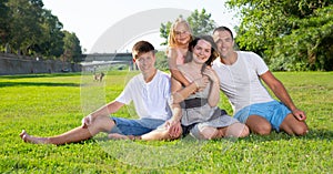 Portrait of cheerful family of four people in the park