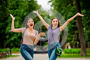 Portrait of cheerful fellows with red lips stick shouting raising hands wearing striped t-shirt in city outdoors