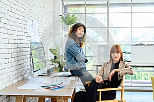 Portrait of cheerful female graphic designers in office. Creative people smiling at the camera during collaborative brainstorming