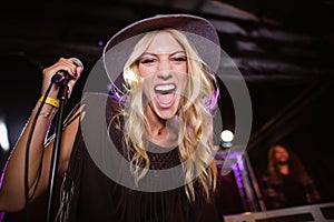 Portrait of cheerful female singer performing at nightclub