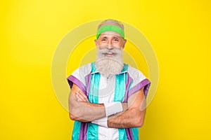 Portrait of cheerful friendly coach granddad crossed hands wear condensed milk color sport suit isolated on yellow