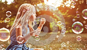 Portrait of a cheerful girl blowing soap bubbles photo