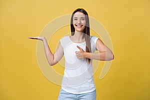 Portrait of a cheerful girl holding copyspace on the palm isolated on a yellow background