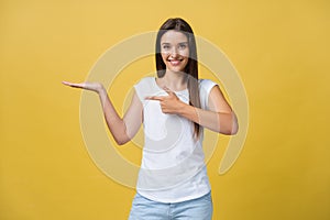 Portrait of a cheerful girl holding copyspace on the palm isolated on a yellow background