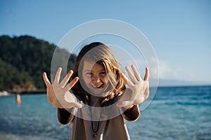 portrait of a cheerful girl, she looks at the camera through outstretched arms